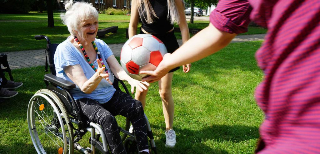 Eine Person in einem Rollstuhl hat spaß mit einem Ball
